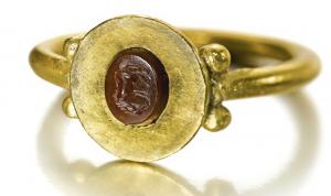 BAG-5058 - Bague à intailleor, pierreBague constituée d'un anneau de section ronde, plus ou moins forte et parfois légèrement aplatie ; le chaton (intaille romaine) est enserré dans une platine formant un large bord lisse tout autour de l'intaille ; de part et d'autre du départ du jonc, deux boules en or.