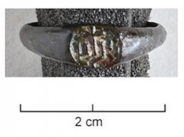 BAG-8011 - Bague IHSbronzeTPQ : 1400 - TAQ : 1550Bague moulée, avec un jonc s'élargissant progressivement pour englober un chaton ovale portant la marque I†HS (lettres gothiques).