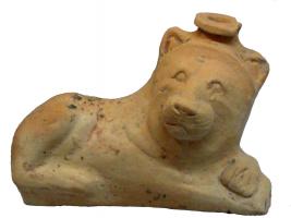 BLS-2001 - Balsamaire zoomorphe : lionterre cuiteBalsamaire moulé représentant un lion couché, la tête sur le côté, les pattes repliées devant lui dans une attitude familière aux félins ; le col du vase émerge au sommet de la tête.