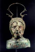 BLS-4022 - Balsamaire en forme de bustebronzeTPQ : 150 - TAQ : 300Balsamaire en forme de buste coupé sous les épaules, représentant un homme barbu (la barbe divisée en deux pointes torsadées et divergentes) ; le corps émerge d'un fleuron ; couvercle avec dispositif de verouillage et anse de supension.