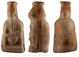 BLS-4125 - Vase plastique : Femme à l'amphoreterre cuiteTPQ : 300 - TAQ : 400Balsamaire en forme de cruche figurant une femme assise tenant sur son giron un vase ansé (cruche, parfois amphore). Anse de préhension à l'arrière.