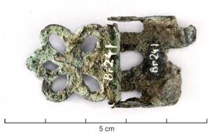 BRE-9002 - Boucle de bretellesbronzeTPQ : 1875 - TAQ : 1950Boucle composée d'une partie ajourée, en forme de quatrefeuille, articulée sur une plaque de tôle découpée.