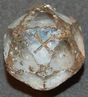 DEJ-4012 - Dé dodécaédriquecristal de rocheTPQ : 1 - TAQ : 300Dé dodécaédrique, en cristal de roche, marqué d'un X et d'un I sur deux faces adjacentes ; hastes bouletées.