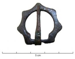 FER-7027 - Fermail hexagonalbronzeTPQ : 1250 - TAQ : 1400Fermail hexagonal (côtés légèrement concaves), orné d'encoches transversales; un côté est aminci pour l'articulation de l'ardillon.