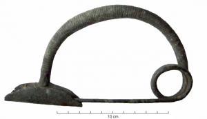 FIB-2091 - Fibule à arc cintré peu renflébronzeFibule à arc cintré, à peine renflé, de section ronde et massive; l'arc forme un arc régulier, couvert d'incisions transversales plus ou moins profondes, dessinant des secteurs ornés d'incisions; le porte-ardillon forme un étrier symétrique de part et d'autre de l'arc; le ressort prolongeant la tête de l'arc est unilatéral à deux ou trois spires.