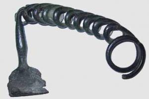 FIB-2670 - Fibule serpentiforme corsebronzeFibule à ressort unilatéral, large spire ; l'arc est constitué d'une série rectiligne d'une dizaine de boucles identiques. Le pied, en tige rectiligne en angle droit avec l'arc, se termine par un porte-ardillon en étrier, en tôle.