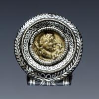 FIB-41941 - Fibule à médaillon impérialfer, bronzeFibule circulaire, en fer orné d'incrustations d'argent ; le motif central est un bouton de cingulum figurant un buste masculin lauré (sans doute impérial), palme devant.
