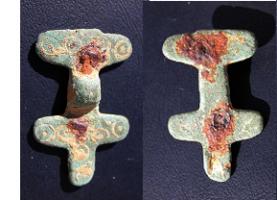 FIB-5149 - Fibule symétrique anséebronzeFibule composée de deux extrémités symétriques, cruciformes avec un décor d'ocelles, autour d'un arc étroit; le porte-ardillon et l'articulation sont en fer et rivetées sur l'arc.