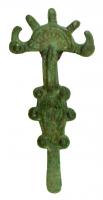 FIB-5204 - Fibule digitée wisigothiquebronzeFibule digitée, à décor excisé de type géométrique; 3 digitations centrales sont en forme de goutte, encadrées par deux têtes de rapaces; entre l'arc et le pied, plaque losangique entourée de disques à boutons.