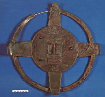 IND-3001 - Objet à identifierbronzeSorte de grand volant en bronze constitué d'un disque central relié par 4 bandes plates à un cercle extérieur; fixation en H au centre.