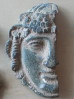IND-9094 - Objet à identifierbronzeApplique figurant un visage, de style classique, avec des grappes de raisin dans les cheveux : Bacchus.