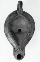 LMP-41302 - Lampe Loeschcke V terre cuiteTPQ : 50 - TAQ : 100Lampe ovoïde à long bec en ogive à volutes. Médaillon vierge.