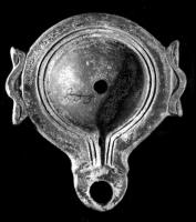 LMP-41548 - Lampe à ailerons et volutes dégénéréesterre cuiteLampe moulée sans anse; réservoir circulaire de profil convexe; bandeau étroit, plat, porte deux ailerons simplifiés sur l'axe horizontal; disque circulaire limité par un sillon qui se poursuit le long d'un petit canal en V.  Bec court arrondi, limité par un trait, à volutes dégénérées. Base circulaire limitée par un sillon.  Engobe rouge vif sur toute la lampe. 