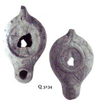 LMP-5216 - Lampe Loeschcke VIII Croix terre cuiteTPQ : 500 - TAQ : 600Lampe à bec long. Médaillon décoré d'une croix. Epaule décorée de points en relief. Planta pedis imprimée sur la base.