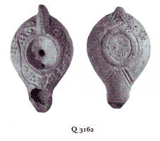 LMP-5223 - Lampe Loeschcke VIII terre cuiteTPQ : 500 - TAQ : 600Lampe à bec long. Médaillon vierge. Epaule ornée de points et d'entrelacs géométriques.