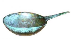 PAT-5002 - PatèrebronzePatère composée d'une simple vasque à profil arrondi, prolongée sur le côté d'un manche plat et légèrement effilé à son extrémité, sans traitement particulier.