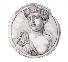 PHA-4019 - Phalère : tête de Ménadebronze, plomb, argentPhalère à décor figuré : buste de jeune femme, la tête penchée sur le côté, vêtements et bandeaux ondulant pour suggérer le mouvement de la danse.