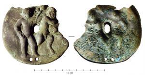PHA-4024 - Phalère (?)bronzePlaque circulaire coulée (?) ou estampée, portant un relief figuré avec deux personnages : Eros bachique, avec canthare et thyrse, et Faune (cornu), portant une outre (?)