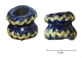 PRL-3549 - Perle gracileverrePerle gracile  (D. perforation > D. section) composée de deux tores annulaires superposés, en verre bleu foncé ; décor rapporté d'une ligne ondée en verre opaque jaune.