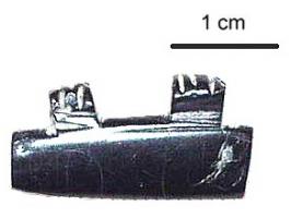 PRL-4174 - Perle à deux tenonsjaisPerle parallélépipédique en jais munie sur un des longs côtés de deux tenons rectangulaires, perforés et ornés de deux-trois sillons.