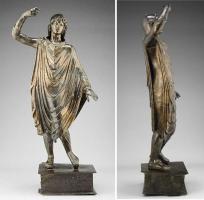 STE-4339 - Statuette : Mars en palliumbronzeMars casqué, appuyé sur une lance et sans doute de l'autre côté sur un bouclier posé au sol, vêtu d'un long manteau qui couvre tout le corps de ses plis.