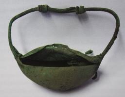 BRC-4124 - Bracelet monétairebronzeTPQ : 75 - TAQ : 250Bracelet dont le corps renflé cache une cavité pouvant servir à conserver sur soi bijou ou pièces de monnaies. Variante à une seule loge unique de grande taille, formant comme une bourse. Le jonc filiforme comporte deux extrémités nouées, procurant peut-être, dans une certaine mesure, une taille réglable ;  la 