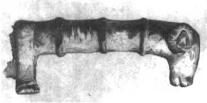 CTO-4076 - Couteau à manche figuréfer, bronzeTPQ : -30 - TAQ : 100Couteau à manche coulé sur la soie de la lame en fer; le manche, assez court, comporte une virole suivie de bourrelets, et se termine par une tête de bélier.