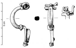 FIB-4494 - Fibule Almgren 22bronzeFibule à ressort protégé par deux plaquettes latérales, corde externe retenue par une griffe ; arc massif et coudé en arc de cercle, interrompu par une nodosité et pied allongé, à porte-ardillon trapézoïdal plein.