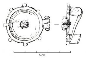 FIB-4547 - Fibule géométrique platebronzeFibule plate, dont la charnière disposée au revers comporte deux plaquettes coulées reliées par un axe en fer. Variante circulaire, avec fréquemment un cabochon incrusté au centre et parfois une couronne niellée; sur le pourtour, 6 petites excroissances et, sur le côté, une charnière latérale indiquant l'adjonction d'un élément articulé.