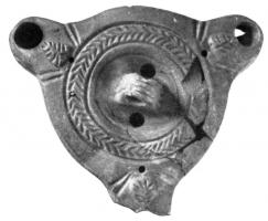 LMP-4070 - Lampe corinthienne tardive à trois becsterre cuiteLampe ronde à trois becs; petit disque non décoré avec en son centre une anse verticale percée; épaule décorée d'arrêtes de poisson; becs ronds bien définis par des traits obliques incisés et décorés d'une feuille.