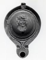 LMP-41304 - Lampe Loeschcke V Masque de satyreterre cuiteLampe à bec court à volutes. Médaillon décoré d'un masque de satyre. Anse perdue.