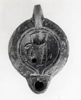 LMP-41321 - Lampe Loeschcke VIII Amphoreterre cuiteLampe à bec court défini par un trait horizontal et deux points imprimés. Médaillon décoré d'une amphore rituelle ornée d'une couronne.