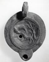 LMP-41325 - Lampe Loeschcke VIII Chien et sanglierterre cuiteLampe à bec court défini par deux traits latéraux. Médaillon décoré d'un chien attaquant un sanglier derrière un arbre, à droite.