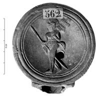 LMP-42697 - Lampe Loeschcke IV : Signiferterre cuiteLampe à bec à volutes. Médaillon cerné par trois cercles incisé, orné d'un personnage marchant vers la gauche. Vêtu d'un simple subligar, portant une lance dans la main droite et une enseigne (?) sur l'épaule gauche, c'est peut-être un gladiateur défilant avant le combat.