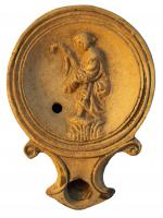 LMP-4292 - Lampe Loeschcke IA : Prêtresse terre cuiteLampe ronde à large bec en enclume, à volutes saillantes pointées Large médaillon concave entouré de trois fi ns anneaux concentriques. Base plate entourée d’un anneau en relief.