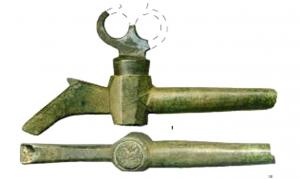 RBN-8001 - Robinet ou cannelle, à clé trilobéebronzeRobinet à noix tronconique, prolongée par un déversoir zoomorphe ; clé plate à trois perforations rondes disposées en triangle.