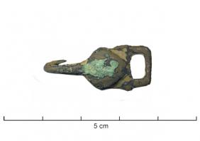 AGR-9220 - Agrafe de col ornée d'une coquille saint JacquesbronzeAttache dont le corps est orné d'une coquille saint Jacques en relief, avec un crochet d'un côté et une boucle rectangulaire de l'autre.