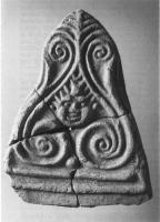 ANT-4034 - Antéfixe : tête et spiralesterre cuiteTPQ : 1 - TAQ : 300Antéfixe cuite en mode A, décorée d'une palmette et d'une tête (Gorgone ?).