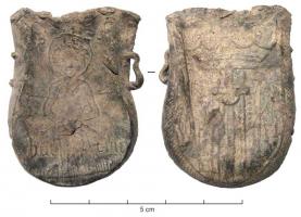 APL-9004 - Ampoule de pèlerinageplombAmpoule en forme de sac, avec deux petites anses annulaires de part et d'autre du col; sur une face, saint assis, la tête nimbée d'une auréole inscrite dans un losange, en bas inscription 