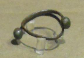 BRC-2055 - Bracelet à tampons sphériquesbronzeBracelet ouvert à jonc mince, de section ovale, terminaisons à tampons sphériques ou subsphériques massifs; la fin du jonc au contact du tampon peut être ornée de filets transversaux.