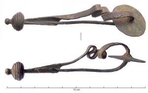 FIB-2085 - Fibule serpentiforme à disque d'arrêtbronzeFibule à arc serpentiforme rubanné ; disque d'arrêt à la tête ; porte-ardillon triangulaire allongé ; sur le pied, bouton sphérique aplati orné de cannelures.