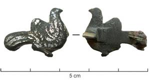 FIB-41679 - Fibule zoomorphe : oiseau (colombe ?)bronzeFibule zoomorphe étamée, en forme d'oiseau à longue queue, une aile redressée, de profil à droite (pigeon ou colombe); le corps est couvert d'incisions parallèles niellées.
