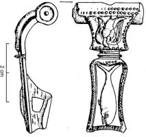 FIB-4749 - Fibule Feugère 18a3bronzeTPQ : 15 - TAQ : 70Type à couvre-ressort cylindrique, à arc très élargi et plat; pied constitué d'une plaque à bords sinusoïdes (en forme de cloche), séparé de l'arc par une moulure; décor constitué de plaques figurées éstampées, brasées sur le corps de la fibule.