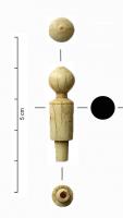 IND-4282 - Bouton de préhensionosÉlément cylindrique de petite dimension et orné, au sommet, d'une sphère pointée. L'autre extrémité présente un net ressaut de forme cylindrique et creux ; il devait s'insérer dans l'objet fini (couvercle de pyxide ? axe de volumen ?).
