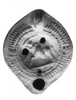 LMP-4057 - Lampe Loeschcke VIII : Centaureterre cuiteTPQ : 400 - TAQ : 500Lampe à bec rond; disque décoré d'un centaure à gauche; anse non percée; épaule ornée d'arrêtes de poisson et de deux 