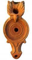 LMP-4330 - Lampe Loeschcke IV : Aigleterre cuiteLampe à volutes et bec en ogive; disque vierge, anse avec réflecteur en forme d'aigle. Argile beige, engobe orange foncé; base plate entourée par un anneau en relief et trois cercles incisés.