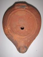 LMP-5099 - Lampe grenouille tardive Busteterre cuiteLampe ovoïdale. Disque décoré d'un buste féminin vers la gauche. Bec en goutte saillant du réservoir. Argile orange, engobe orange.