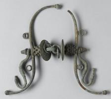 MRS-3011 - Mors de bridebronzeMors de bride composé de deux appliques latérales en S allongés, entre lesquelles s'insère un mors brisé sur lequel sont enfilés divers éléments (anneau à picots, disques…)
