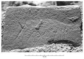 PDS-4481 - Poids en pierre : 38 libraepierrePoids en pierre en forme de parallélépipède ; parfois équipée d'une anse et/ou de logements pour des coulées de plomb afin d'ajuster la masse ; sur une face, éventuellement, marque incisée précisant la masse en chiffres romains et en livres