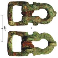 PLB-5588 - Plaque-boucle rigidebronzePlaque-boucle rigide, à corps rectangulaire allongé, percé d'un ajour en forme d'entrée de serrure ou de 8, avec des ergots sur le pourtour ; boucle rectangulaire ou réniforme.
